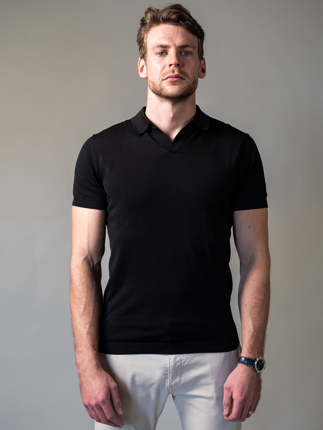 Smart black knitted polo shirt featuring a revere collar and tapered body