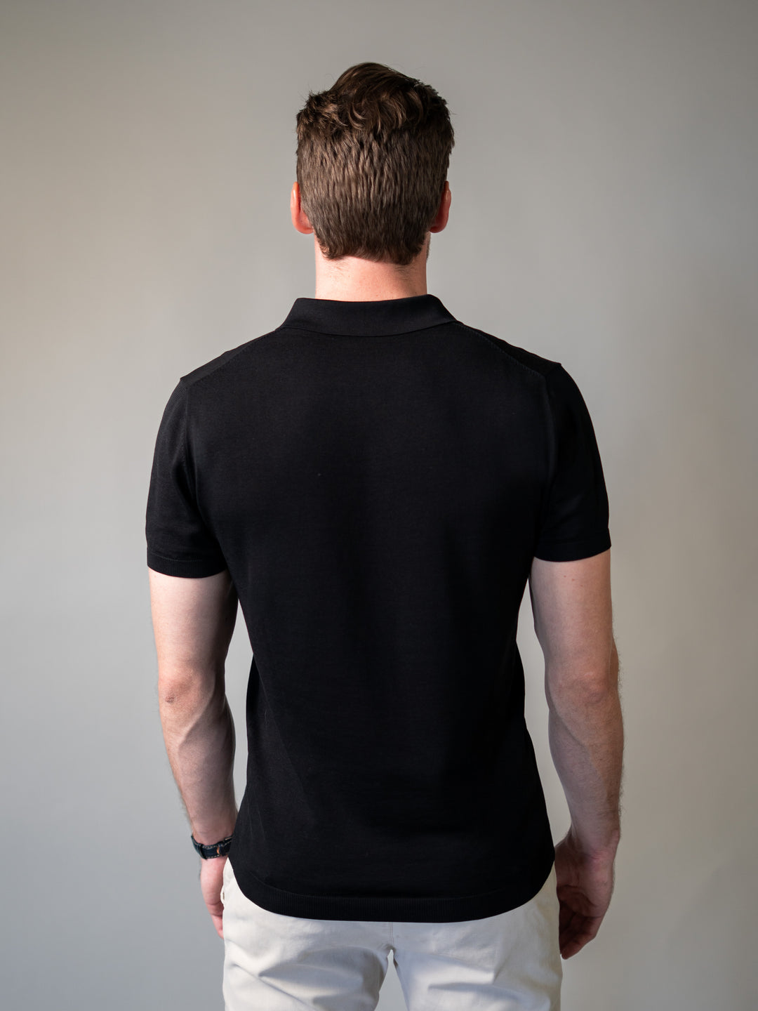 Tapered fit black knit polo with revere collar for refined everyday wear